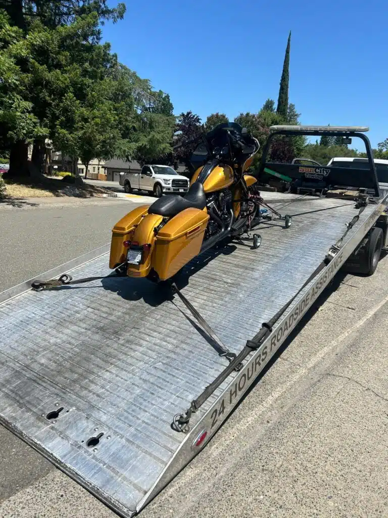 Motorcycle strapped down on a Sun City Towing flatbed tow truck