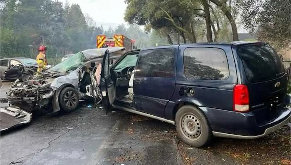 Severely damaged vehicles after a car accident with emergency responders on scene.