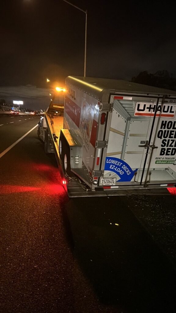 Medium-duty box truck being towed at night