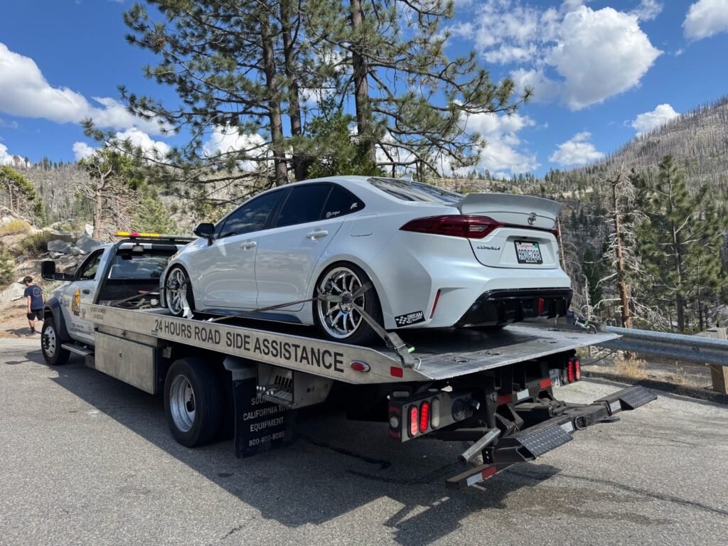 Sun City Towing flatbed carrying a white sedan in South Lake Tahoe