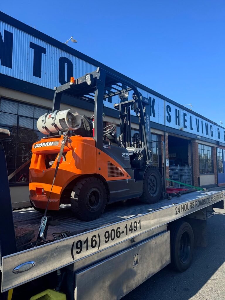Forklift loaded on a Sun City Towing flatbed for transport